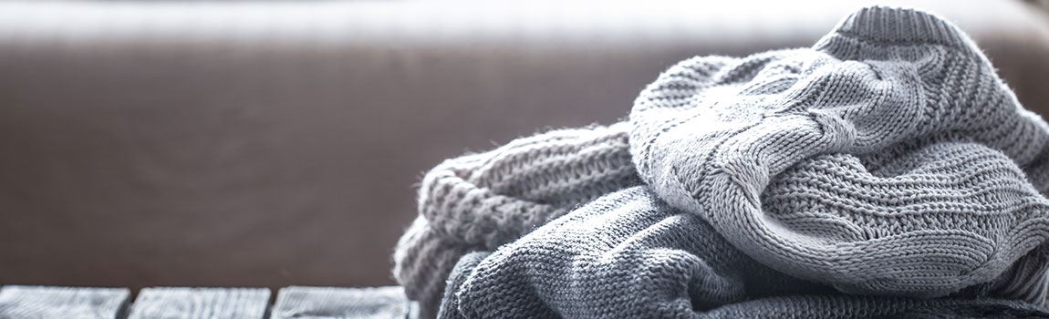 Verschiedene Wollpullover in grau