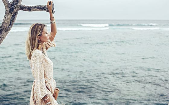 Frau im Leinenkleid am Meer in Italien