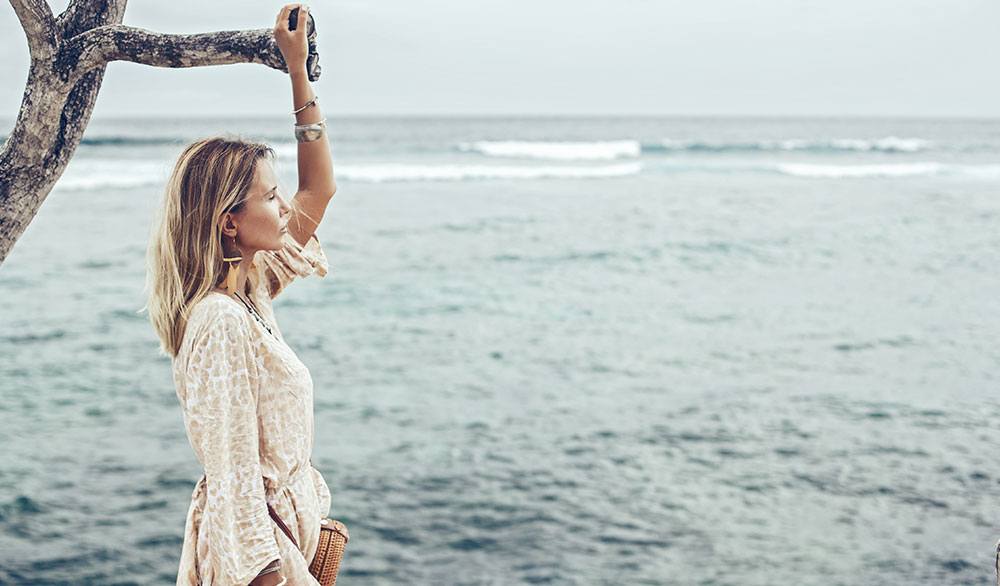 Frau im Leinenkleid am Meer in Italien