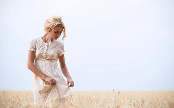 Frau in Sommerkleid in einem Feld in Italien