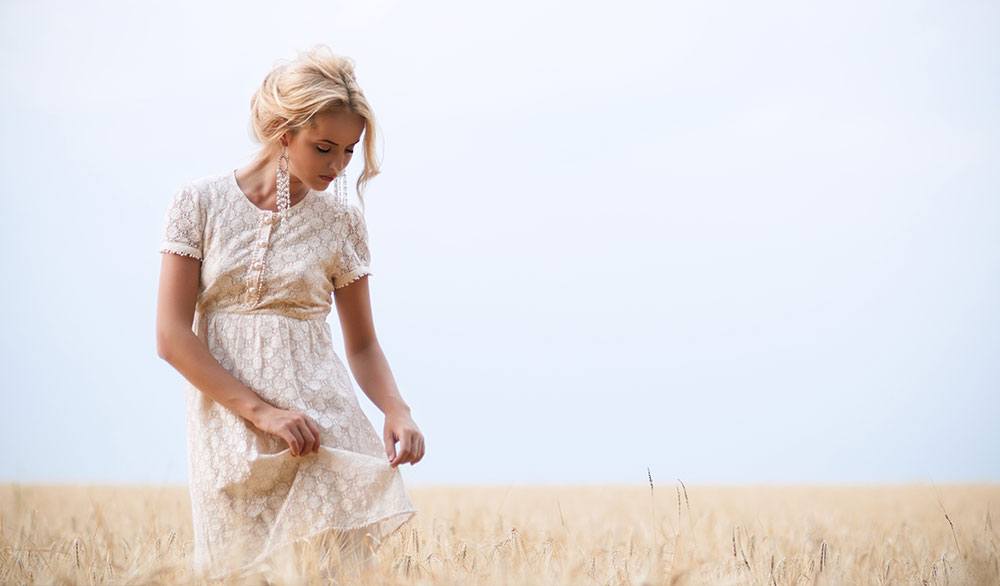 Frau in Sommerkleid in einem Feld in Italien