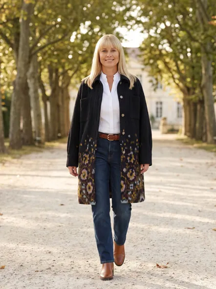 Frau in langem Herbstmantel im Park